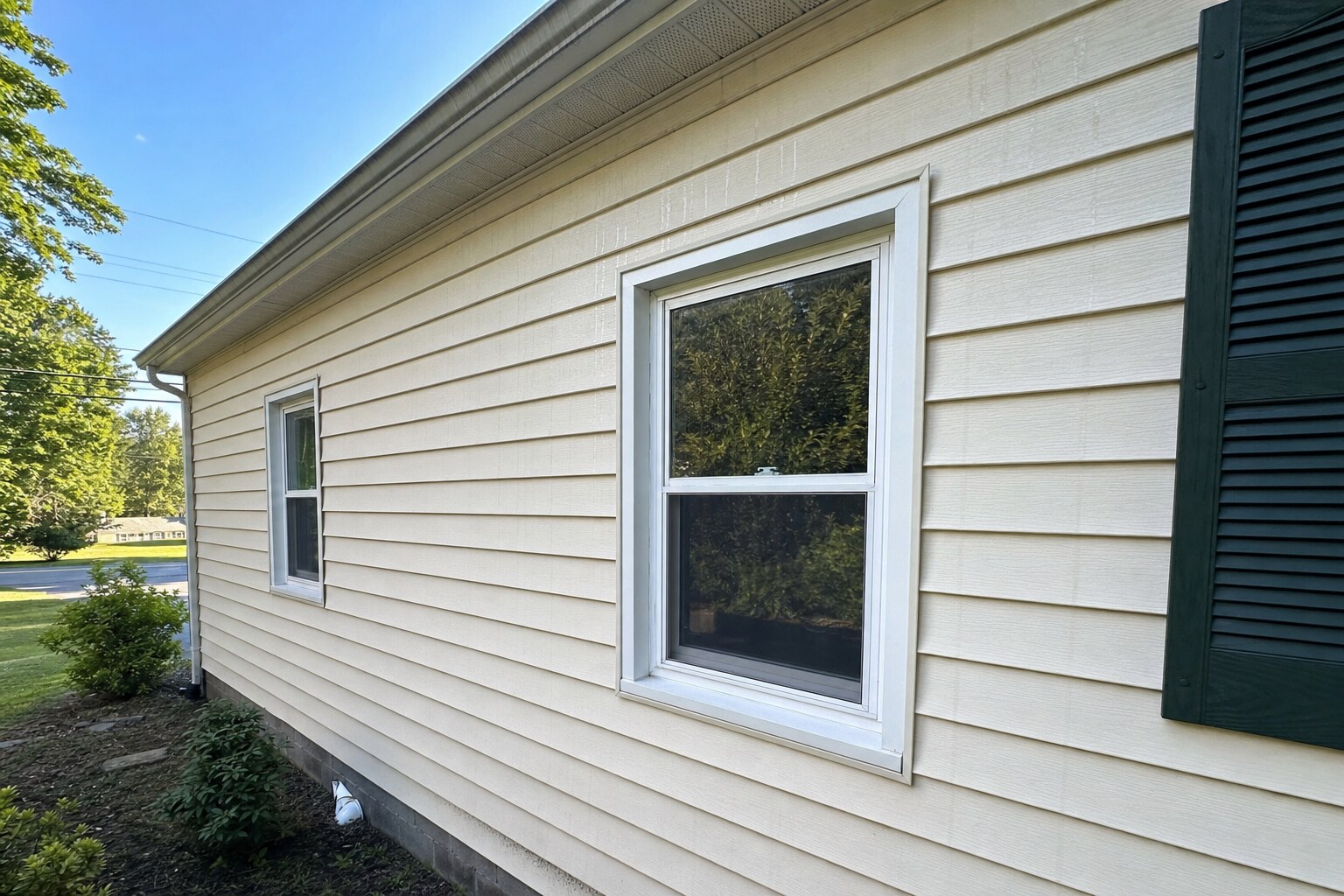 Cream vinyl-siding close-up showing clean texture in side-rake light